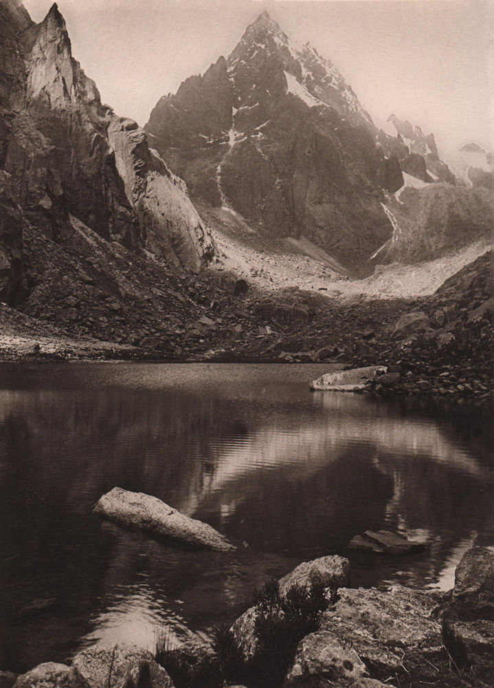 Mount Yunque is reflected by the waters of a glacial lake. Bolivia 1928 print
